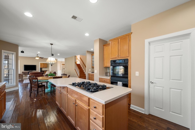 kitchen with visible vents, black appliances, a kitchen island, dark wood finished floors, and light countertops