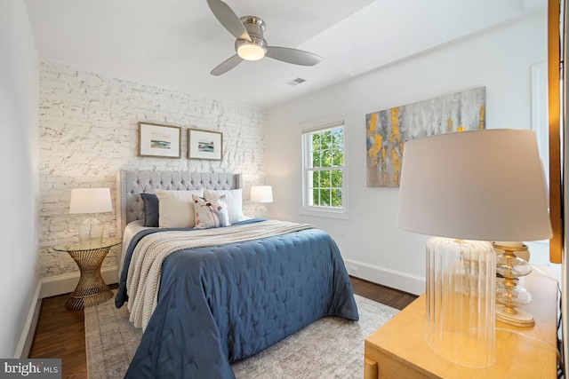 bedroom featuring baseboards, ceiling fan, wood finished floors, and visible vents