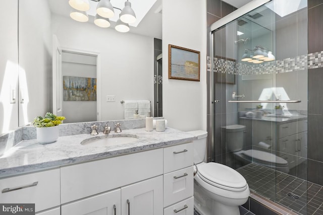 bathroom with vanity, a stall shower, and toilet