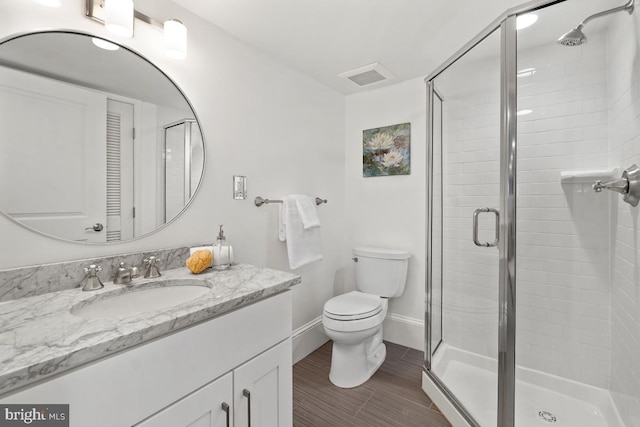 full bath featuring vanity, toilet, wood finished floors, visible vents, and a stall shower