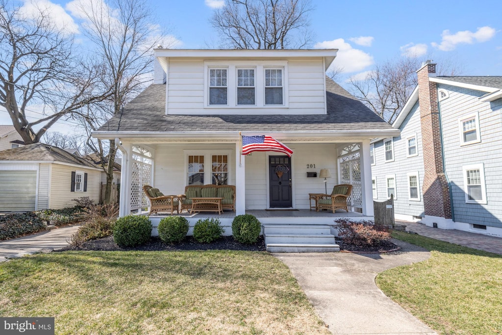 bungalow featuring a porch, a front yard, and a shingled roof