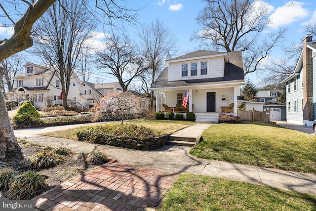 view of front facade with a residential view, a porch, and a front lawn