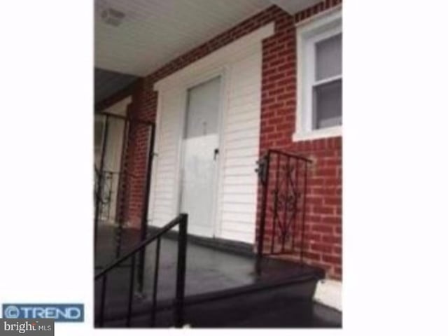 doorway to property featuring brick siding