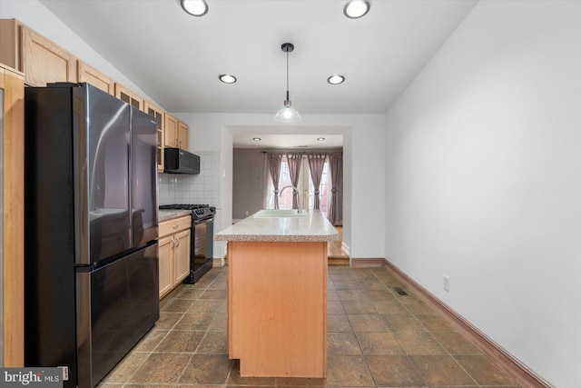 kitchen with light brown cabinets, black appliances, light countertops, and a sink