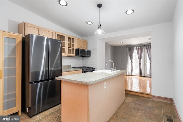 kitchen with visible vents, black appliances, light brown cabinetry, a sink, and tasteful backsplash