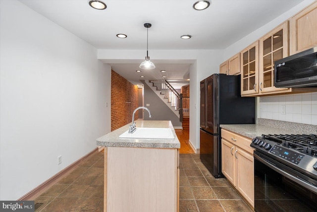 kitchen featuring light brown cabinetry, gas range, and a sink