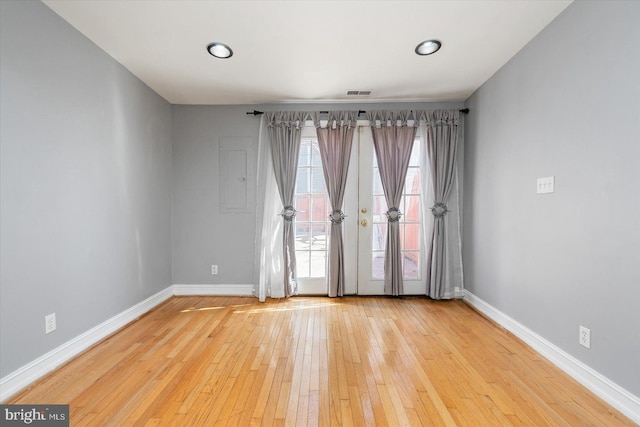 spare room featuring visible vents, baseboards, and wood-type flooring