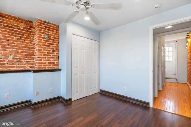 unfurnished bedroom with a closet, a ceiling fan, baseboards, and wood finished floors