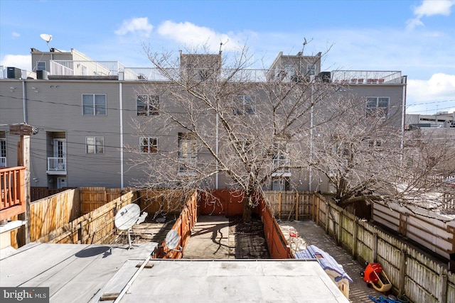 rear view of house with a fenced backyard