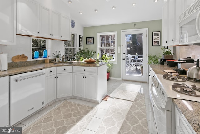 kitchen with white cabinetry, white appliances, and backsplash