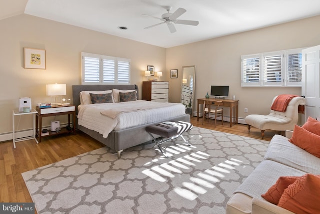 bedroom featuring wood finished floors, visible vents, baseboards, lofted ceiling, and ceiling fan