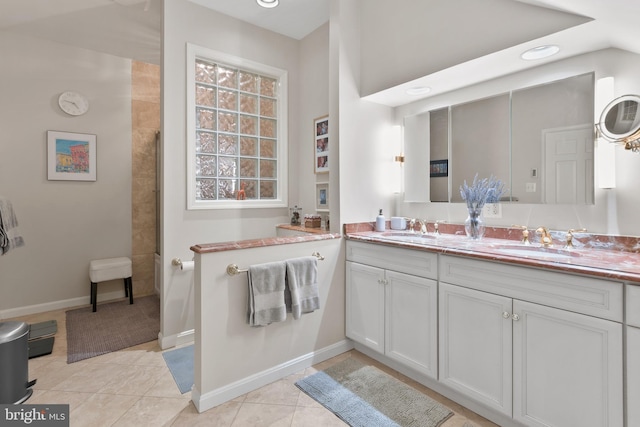 bathroom featuring tile patterned floors, double vanity, baseboards, and a sink