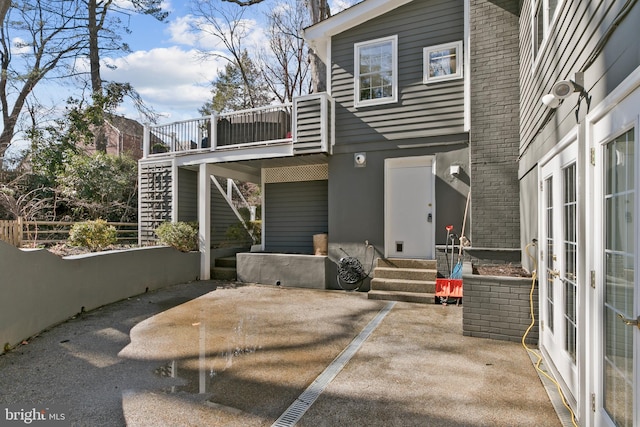 back of house featuring stairway, uncovered parking, stucco siding, a deck, and a patio area