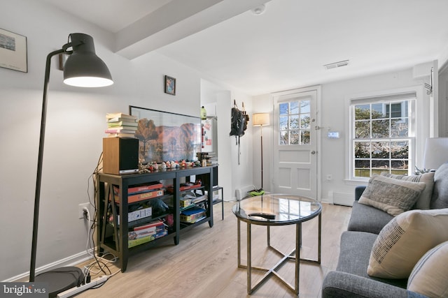 living area with light wood-style flooring, baseboards, and visible vents