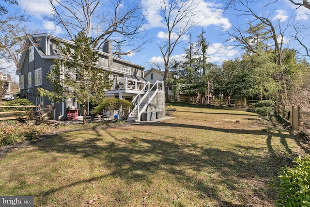 view of yard featuring stairs, a deck, and fence