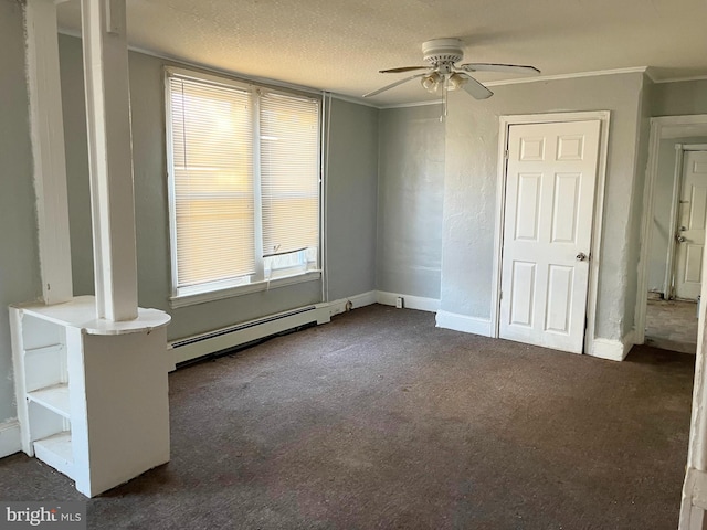 unfurnished bedroom with dark colored carpet, multiple windows, baseboard heating, and a textured ceiling