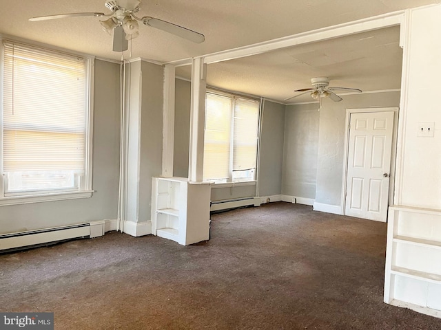 empty room with dark colored carpet, a baseboard radiator, baseboards, and a ceiling fan