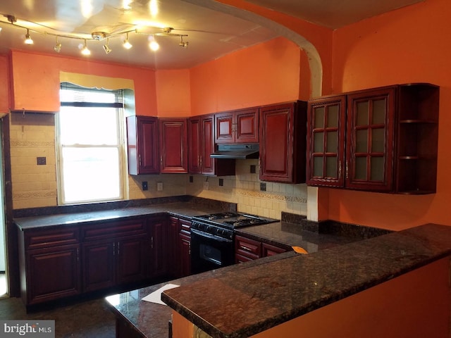 kitchen with under cabinet range hood, backsplash, black gas stove, a peninsula, and dark brown cabinets