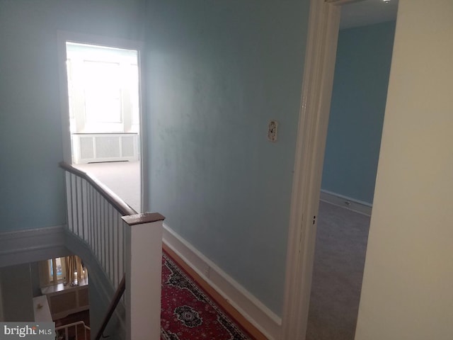 hallway featuring an upstairs landing, cooling unit, and baseboards