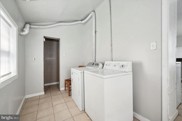 clothes washing area with laundry area, light tile patterned floors, baseboards, and independent washer and dryer