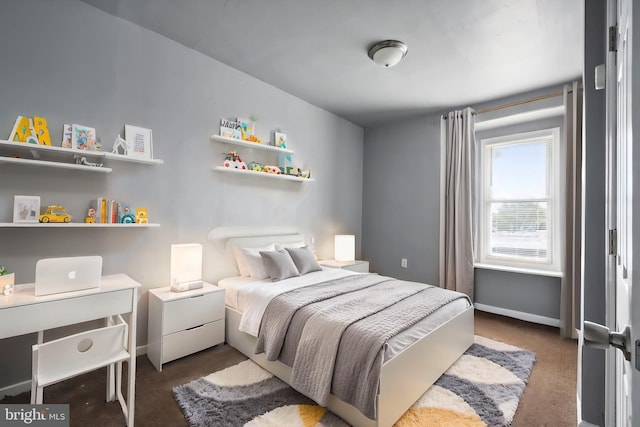 bedroom featuring dark colored carpet and baseboards