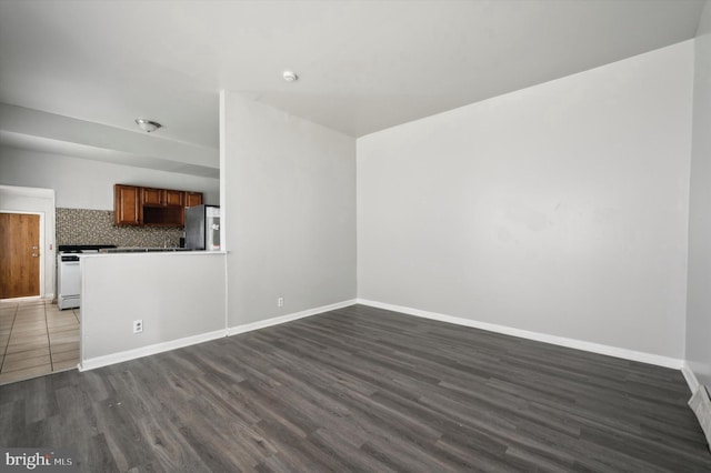 unfurnished living room featuring dark wood finished floors and baseboards