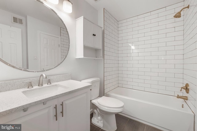 bathroom with visible vents, toilet, vanity, wood finished floors, and washtub / shower combination