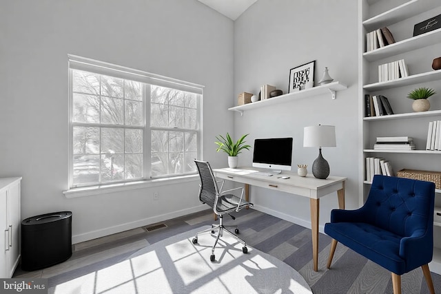 office space featuring visible vents, baseboards, and wood finished floors