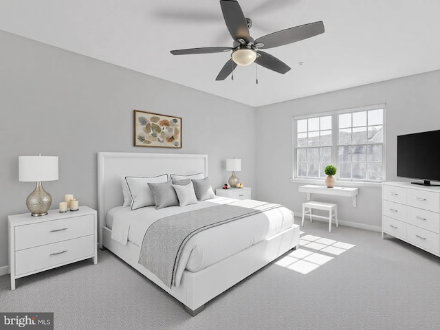 bedroom featuring baseboards, light colored carpet, and a ceiling fan