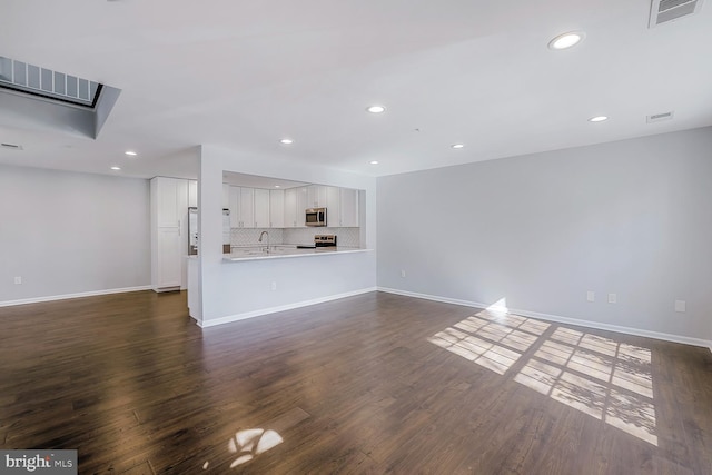 unfurnished living room featuring recessed lighting, visible vents, baseboards, and dark wood-style flooring