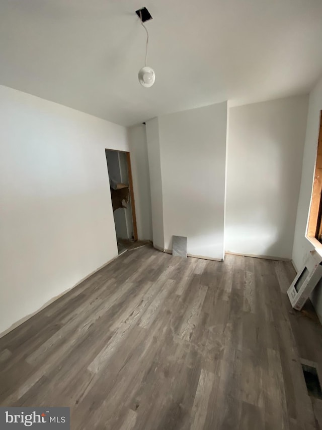 empty room featuring wood finished floors and a wall mounted AC