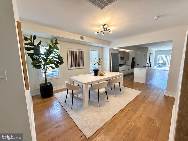 dining room with visible vents, baseboards, and light wood-style floors