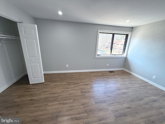 unfurnished bedroom with recessed lighting, dark wood-style floors, and baseboards