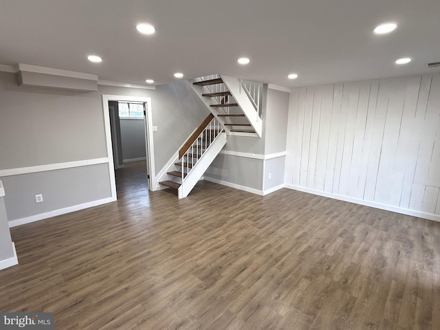 finished basement featuring visible vents, baseboards, stairs, recessed lighting, and dark wood-style flooring