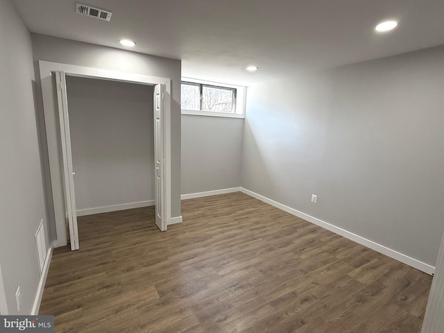 below grade area with recessed lighting, wood finished floors, visible vents, and baseboards