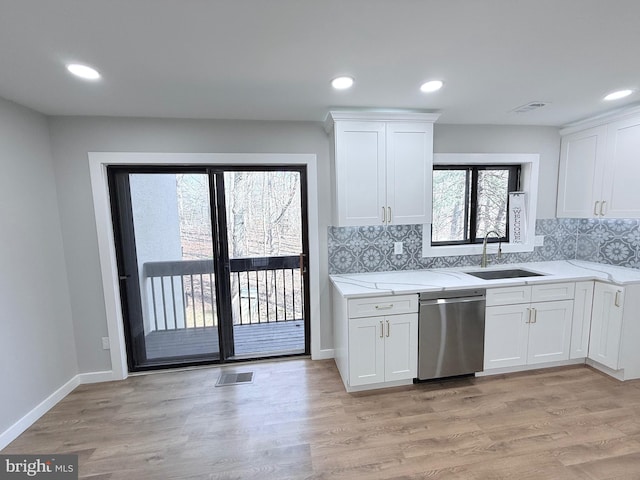 kitchen with visible vents, a sink, white cabinetry, light wood-style floors, and dishwasher