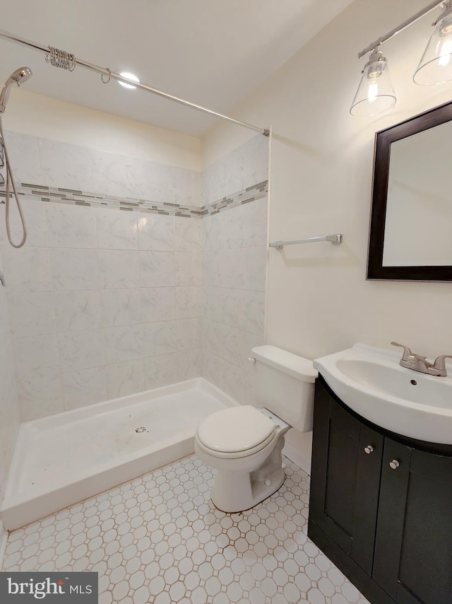 bathroom featuring vanity, toilet, and a stall shower