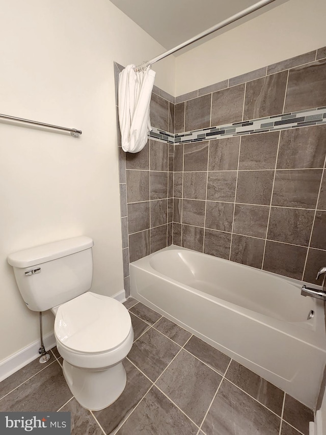 bathroom with baseboards, shower / tub combination, toilet, and tile patterned flooring