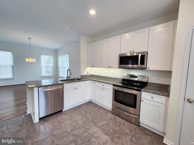 kitchen featuring a sink, white cabinetry, backsplash, and stainless steel appliances