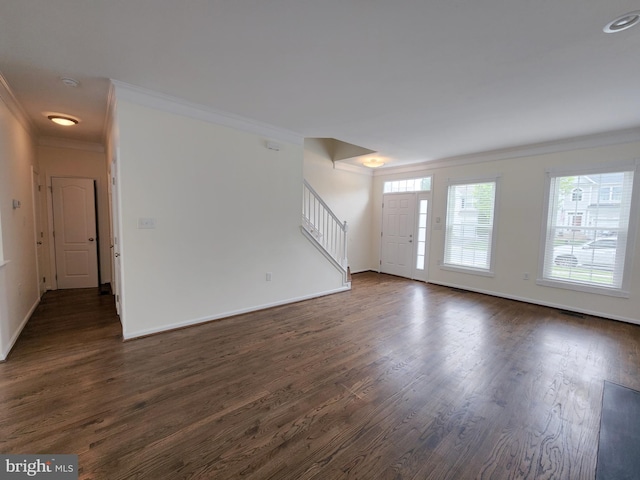 unfurnished living room with dark wood-style floors, baseboards, ornamental molding, and stairs