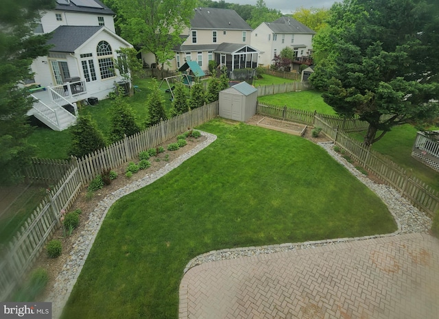 view of yard featuring a fenced backyard, a residential view, a storage shed, and an outdoor structure