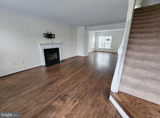 unfurnished living room with dark wood-type flooring, baseboards, stairway, a fireplace with flush hearth, and ornamental molding