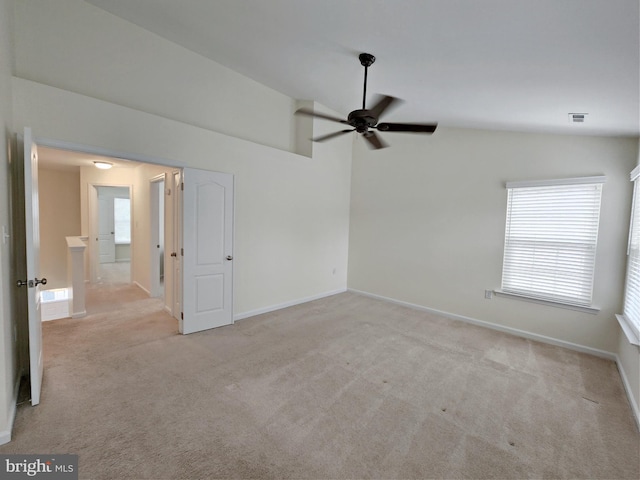 carpeted spare room featuring visible vents, a ceiling fan, baseboards, and vaulted ceiling