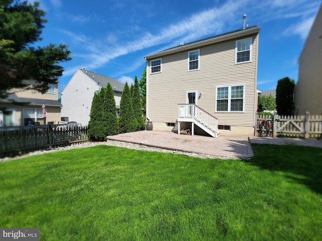 rear view of house with a patio, a lawn, and fence