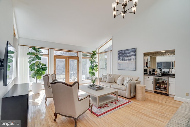 living area featuring french doors, beverage cooler, light wood-type flooring, and a wealth of natural light