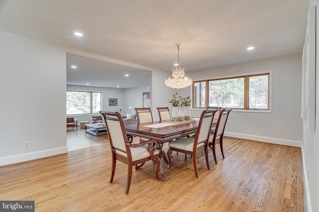 dining area with an inviting chandelier, light wood-style flooring, recessed lighting, and baseboards