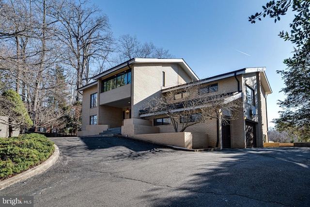 exterior space with aphalt driveway and brick siding