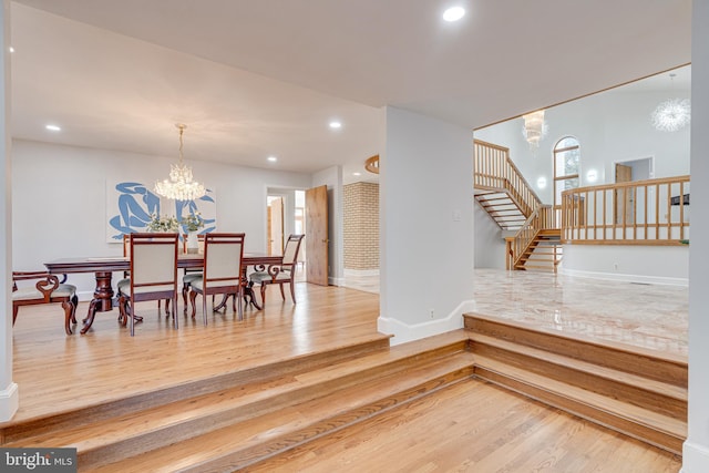 dining room featuring stairway, a notable chandelier, wood finished floors, and recessed lighting