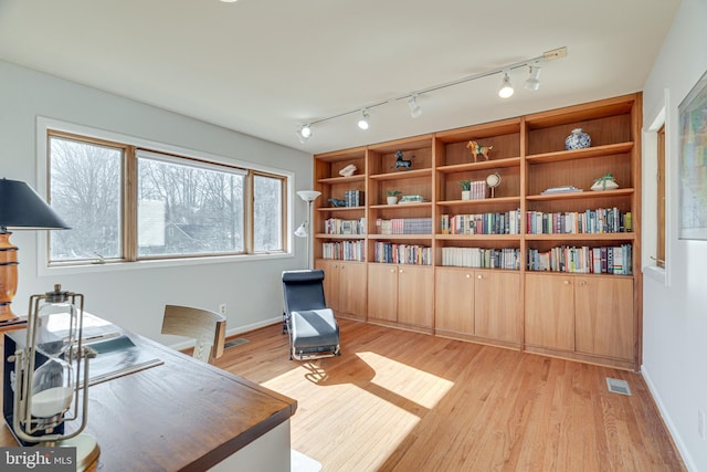 home office with visible vents, baseboards, and light wood finished floors