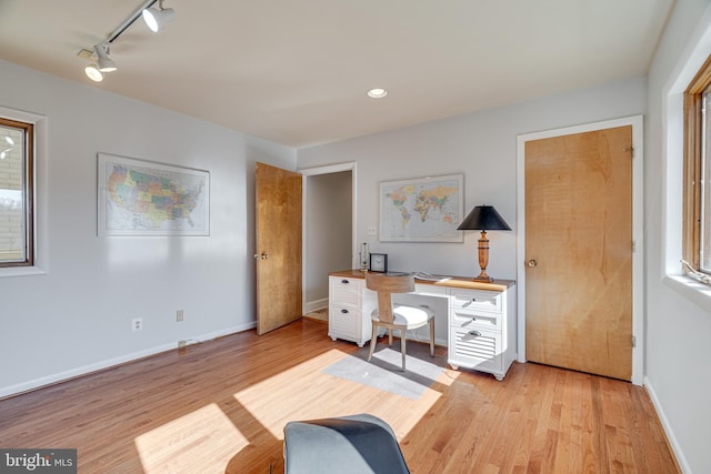 office featuring baseboards, rail lighting, and light wood finished floors